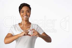 Smiling women making heart shape with their fingers around pink ribbon