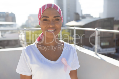 Smiling woman in the city with breast cancer awareness