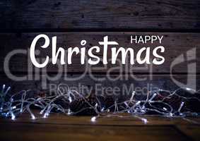 Happy Christmas text with lights on wood