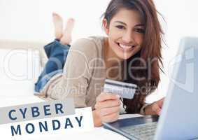 Cyber Monday Sale Woman lying in front of laptop with creditcard in her hand