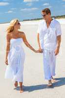 Happy Man Woman Couple Holding Hands Walking on a Beach