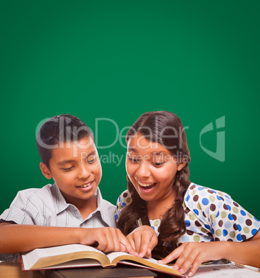 Blank Chalk Board Behind Hispanic Boy and Girl Having Fun Studying