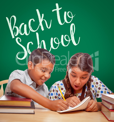 Back To School Written On Chalk Board Behind Hispanic Boy and Girl