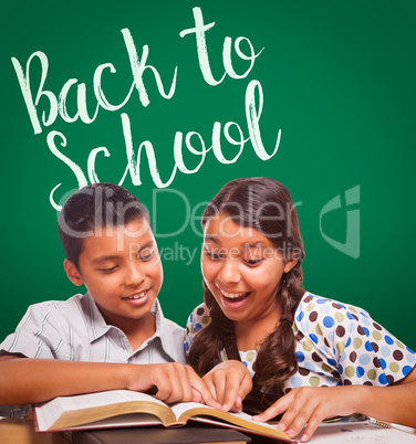 Back To School Written On Chalk Board Behind Hispanic Boy and Girl