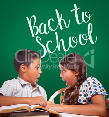 Back To School Written On Chalk Board Behind Hispanic Boy and Girl