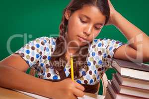 Hispanic Girl Student with Pencil and Books Studying by Chalkboard