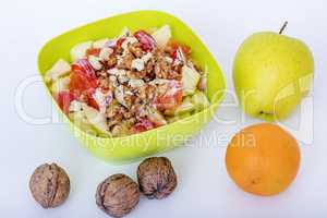 Fruit bowl with sliced apples oranges and nuts