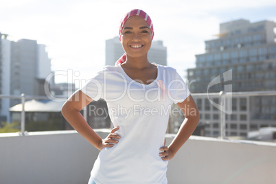 Smiling woman wearing mantra scarf with breast cancer awareness