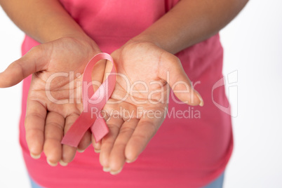 Woman holds ribbon in both hands for breast cancer awareness