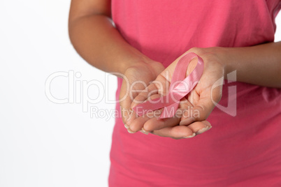 Woman displays pink ribbon in hands