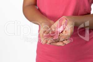 Woman displays pink ribbon in hands
