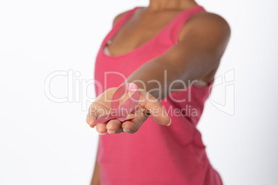 Woman stretches arm showing pink ribbon