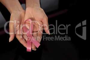 Hands show pink ribbon