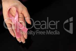 Hand showing pink ribbon for breast cancer awareness