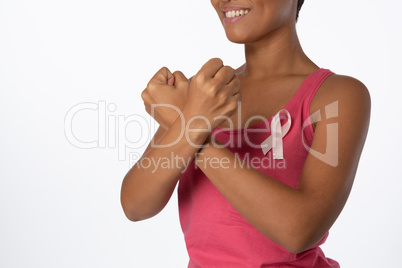 Smiling woman crossing arms for breast cancer awareness