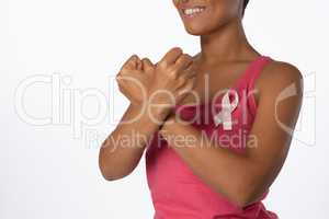 Smiling woman crossing arms for breast cancer awareness