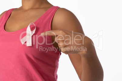 Woman pointing at ribbon for breast cancer awareness