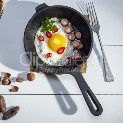 black round frying pan with fried chicken egg and sausages