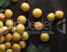 ripe yellow apricots on a brown wooden table