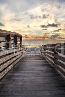 Boardwalk leading to the ocean at Vanderbilt Beach at sunset