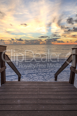 Boardwalk leading to the ocean at Vanderbilt Beach at sunset