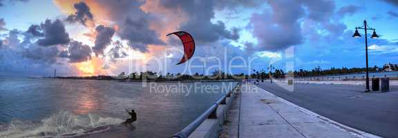Kite surfer surfs alongside the Edward B. Knight Pier at sunset