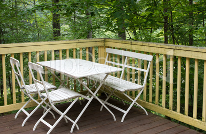 Table with chairs on the veranda in the forest house