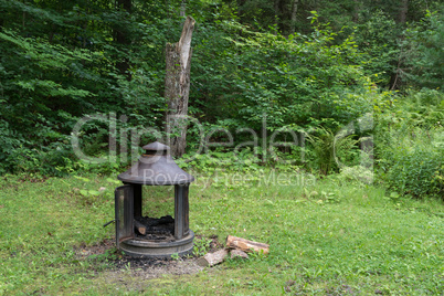 Stove and firewood in the yard on the grass