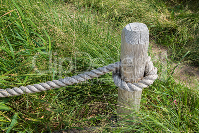 Thick fencing rope tied to a wooden post