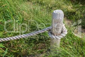 Thick fencing rope tied to a wooden post
