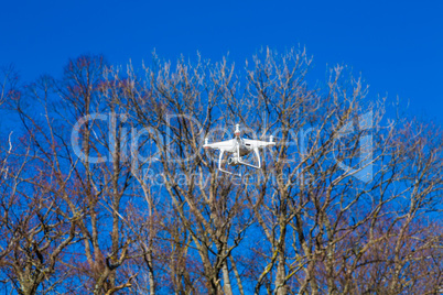 drone flies in front of trees