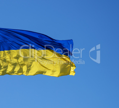 ukrainian textile flag develops against the blue sky