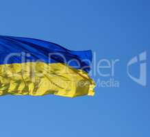 ukrainian textile flag develops against the blue sky