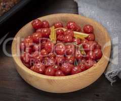 pickled red cherry tomatoes in a wooden bowl