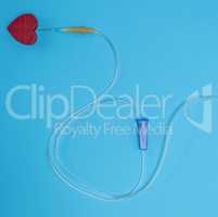 empty plastic dropper with needles and red heart on blue backgro