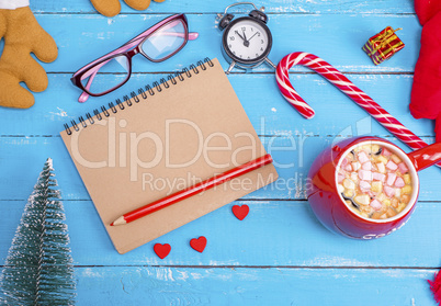 empty paper notebook and cup of hot chocolate with marshmallow