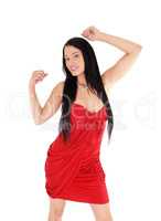 Happy woman dancing in a red dress and black hair
