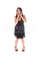Scared woman standing in black dress hands on face