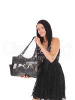 Woman showing of her new purse in a black dress
