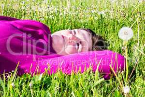 Woman lying on the lawn in the grass
