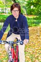 Woman riding a bicycle in autumn park