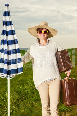 Woman wearing sun screen and holiday suitcase