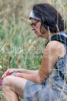 Woman is sitting in the tall grass