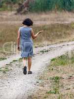 Woman is walking alone on dirt road