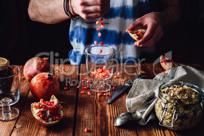 Man Puts Pomegranate Seeds into the Glass.