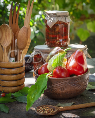 vegetables in a brown clay dish and jars with canned eggplants