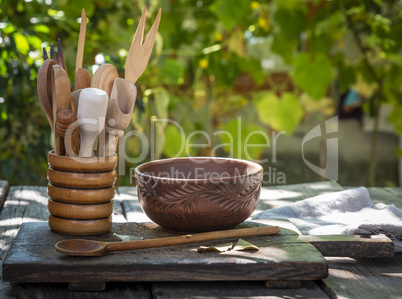 empty clay plate and various wooden kitchen objects