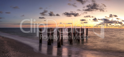 Dilapidated ruins of a pier on Port Royal Beach at sunset