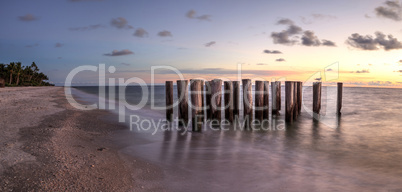 Dilapidated ruins of a pier on Port Royal Beach at sunset