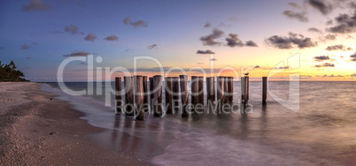 Dilapidated ruins of a pier on Port Royal Beach at sunset